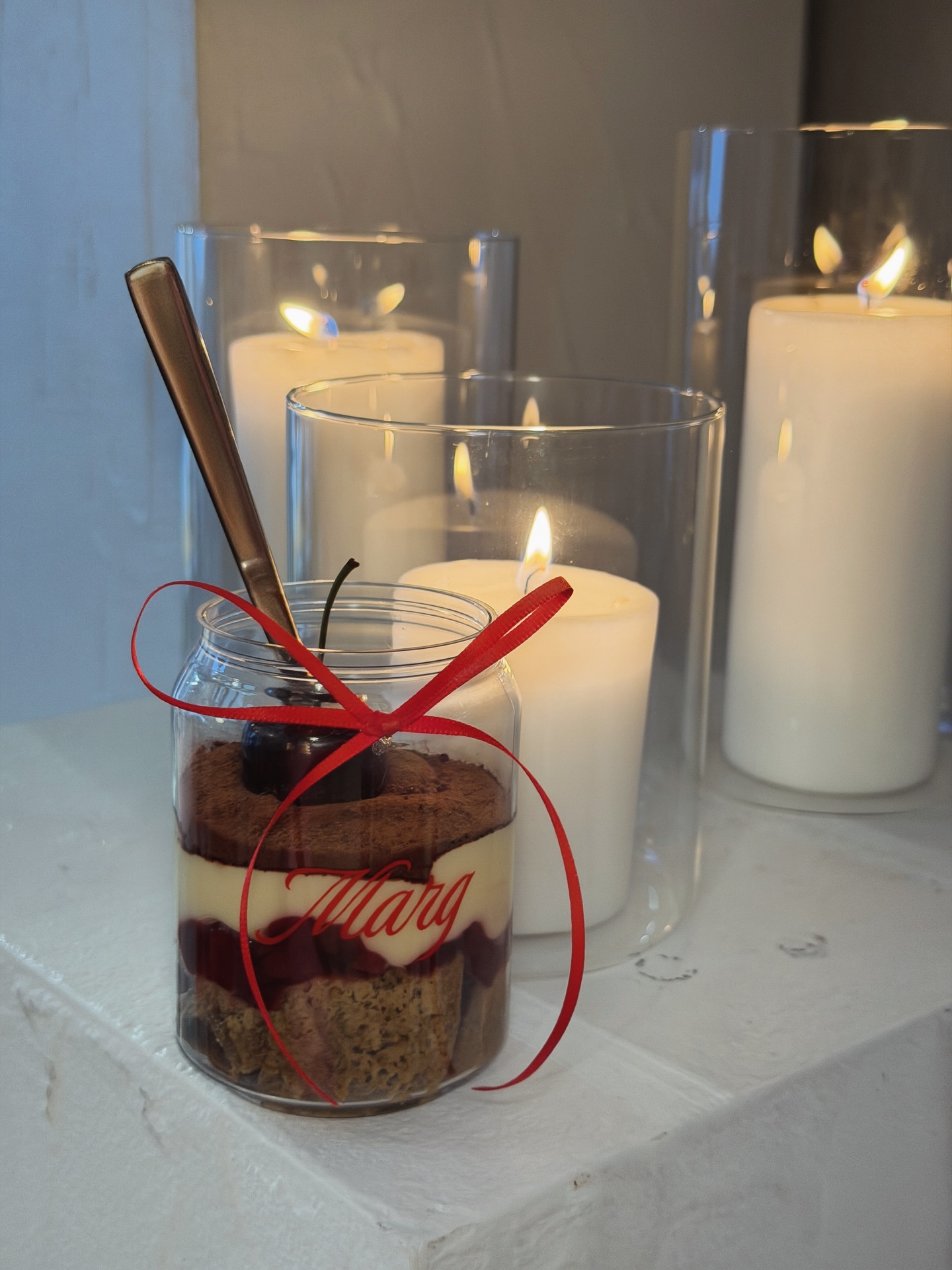 Personalised Cherrymisu jar with red ribbon and name, at a candlelit event